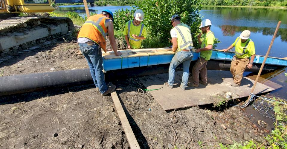 Attaching two flotation planks to each pipe with nylon strapping.