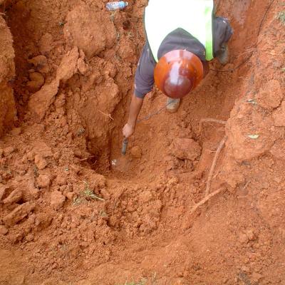 Utility crewman places a leak detection device on a pipe.