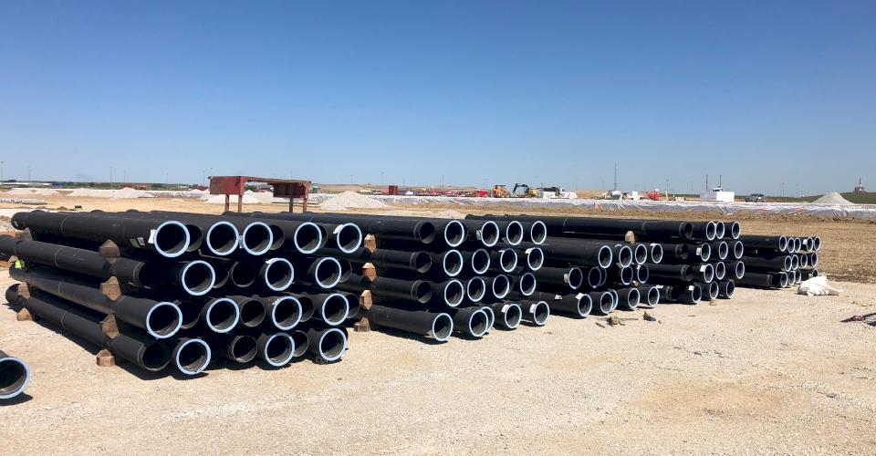 A stack of Ductile iron pipe at a job site.