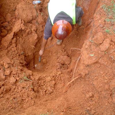 Utility crewman places an acoustic leak detection device on a pipe.