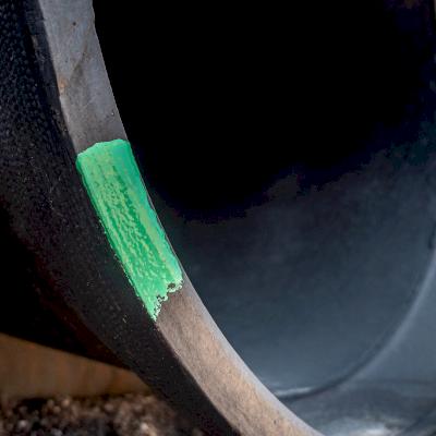 Up-close gauged full length pipe marked with green paint on the bell face.