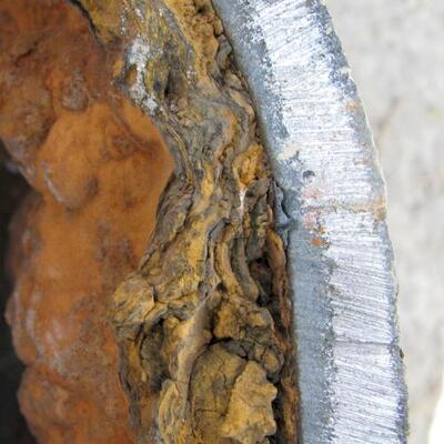 The deposition of ferrous oxide (tubercles) from the water in UNLINED iron pipe.