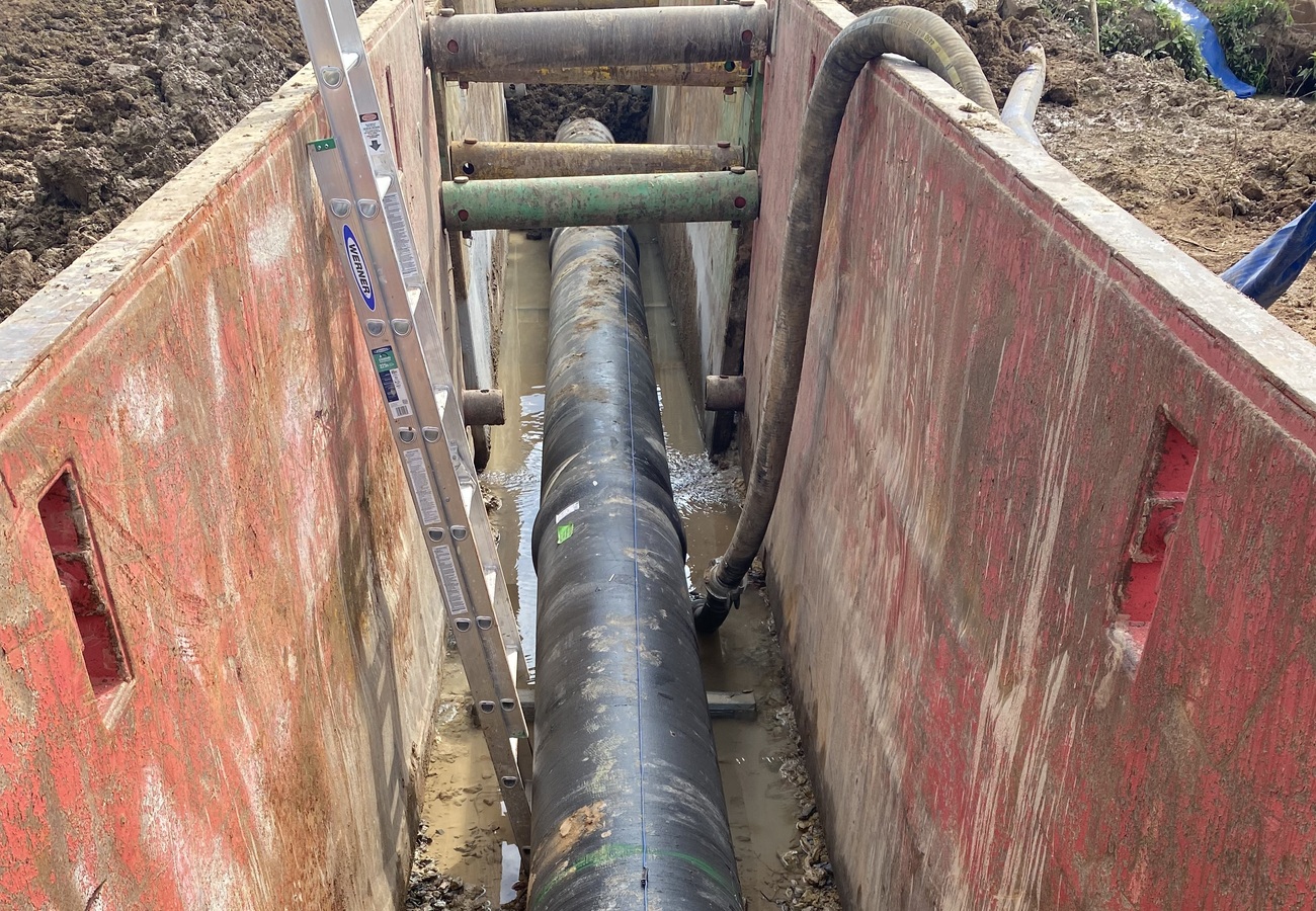24” pipe in a trench surrounded by a trench box.