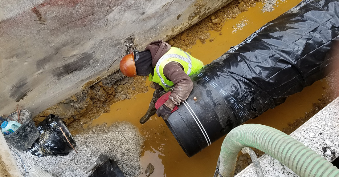 Ductile iron pipe installation in a wet trench.
